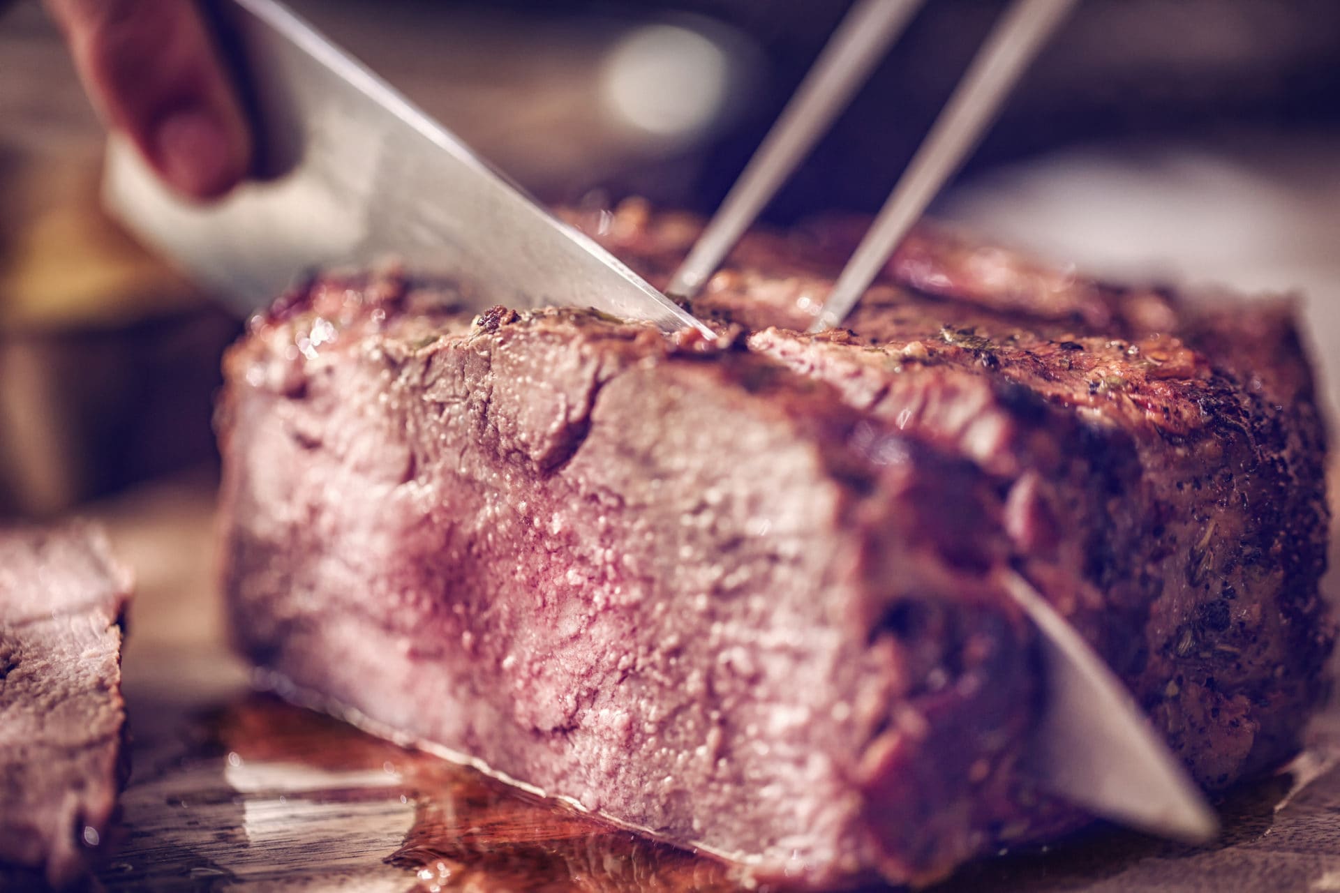 Knife cutting roast meat in Cambridge